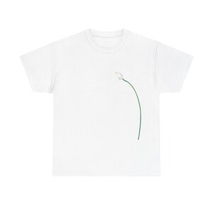 Könnte beinhalten: Weißes T-Shirt mit minimalistischem Blumendesign. Das Design zeigt eine weiße Blütenknospe und einen grünen Stiel. Das T-Shirt besteht aus einem weichen, bequemen Material, das sich für Freizeitkleidung eignet. Das Design ist schlicht und elegant.