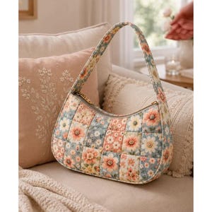 Könnte beinhalten: Eine gesteppte Hobo-Tasche mit einem Patchwork-Design aus Blumenmustern in Pfirsich-, Hellblau- und Cremetönen. Die Tasche hat einen einzelnen Schulterriemen, eine geschwungene Silhouette und einen Reißverschluss entlang der Oberkante des Stoffes.