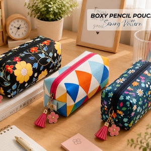 May include: Three rectangular pencil pouches with zippers and decorative pink flower and tassel charms. One is black with yellow flowers, one features a colorful geometric triangle pattern, and one is dark blue with a small white floral print.