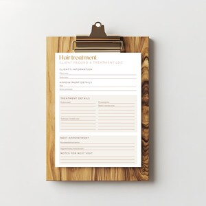 Op de afbeelding: Een houten clipboard met een goudkleurige clip met een "Hair Treatment" klantrecord en behandelingslogboek. Het logboek bevat secties voor klantinformatie, afspraakdetails, behandelingsdetails en notities.