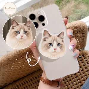 May include: A clear smartphone case featuring a custom die-cut sticker of a fluffy cat with blue eyes and white and grey fur. The sticker is applied to the back of the phone, which has a triple-lens camera system. The brand name LeeVana is visible.