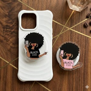 May include: A white ceramic mug with a black handle and the text "But First, Coffee" in a black, bold font. The mug is on a white surface.