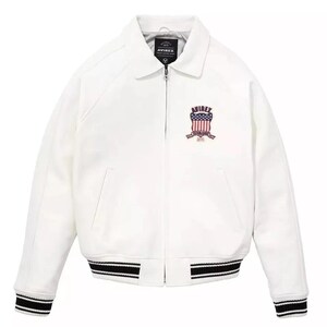 May include: White jacket with a collar and a zipper closure. The jacket features a black and white striped hem and cuffs. An emblem with red, white, and blue details is on the chest. The brand name "AVIREX" is visible.