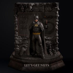 May include: A Batman statue in a black costume with a yellow belt and bat symbol. The statue is on a dark base with the text "LET'S GET NUTS". The background features a textured wall with bat symbols.