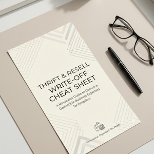 May include: A guide titled "Thrift & Resell Write-Off Cheat Sheet" with geometric design. A black pen and glasses are next to the guide. A small succulent in a white square pot is also present.