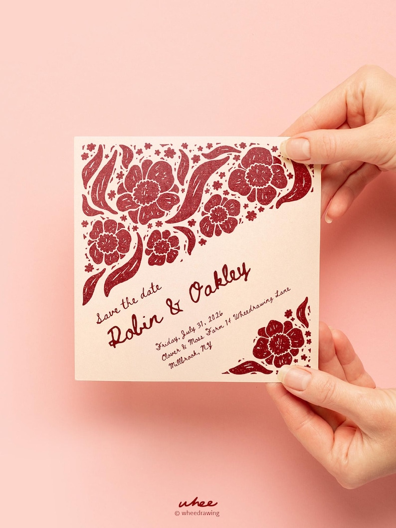 May include: A square cream-colored save the date card featuring dark red floral illustrations in the corners. The text reads: Save the date, Robin & Oakley, Friday, July 31, 2026, Clover & Moss Farm 14 Wheedrawing Lane, Millbrook, NY.