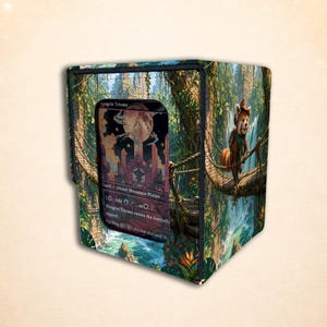 Op de afbeelding: Een rechthoekige deckbox met een levendige jungle-scène met een rode panda op een touwbrug. Het voorpaneel heeft een doorzichtig venster met een Raugrin Triome-ruilkaart met tekst waaronder Land, Island Mountain Plains en Cycling.