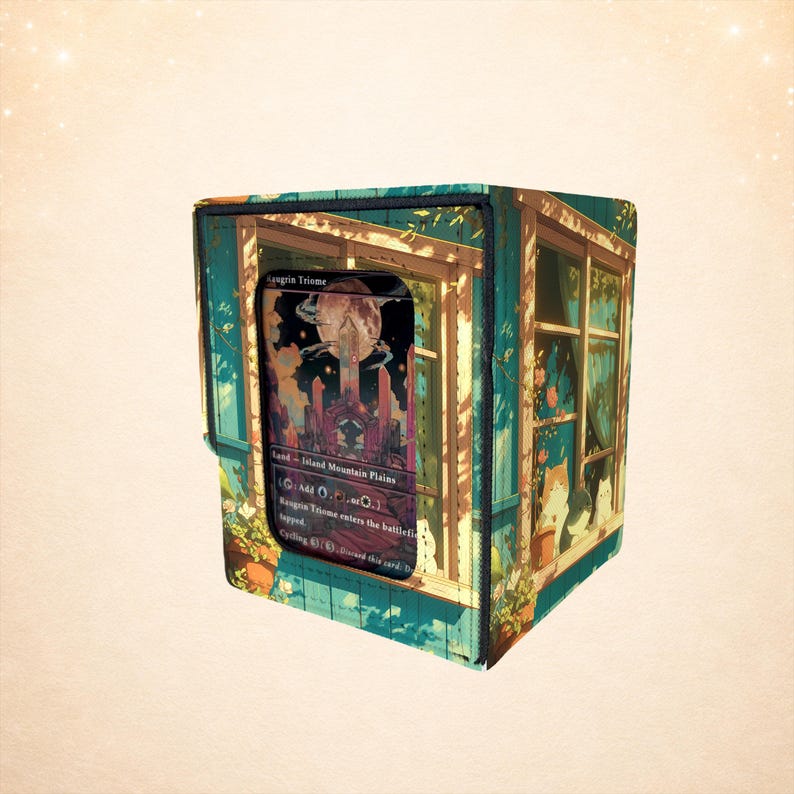 Puede incluir: Una caja rectangular para barajas de cartas con una ilustraci&oacute;n impresa de una ventana que da a una escena nocturna con una luna y un edificio. La caja tiene una ventana frontal transparente que muestra una carta Raugrin Triome y gatos.