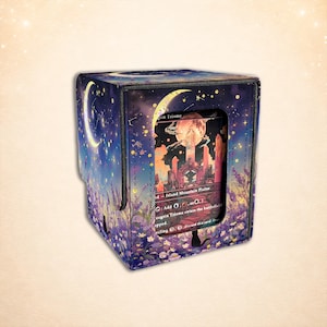 May include: A rectangular deck box featuring a night sky illustration with a crescent moon, stars, and purple flowers. A cutout window on the front displays a trading card with a landscape illustration of a red moon, crystals, and text.