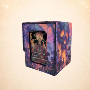 May include: A square card storage box with a colorful fantasy art design. The box is primarily purple with orange and red accents. A card with the text "Angrin Triome" is visible in the front.