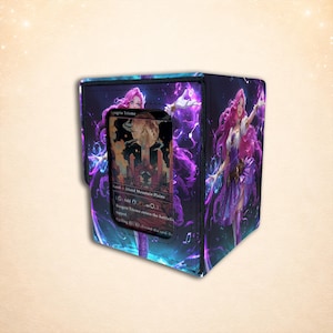 Puede incluir: Una caja para barajas rectangular con una vibrante ilustración de fantasía en tonos morados y azules de un personaje con cabello largo y rosa. El panel frontal incluye una ventana transparente que muestra una carta coleccionable Raugrin Triome.