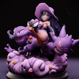 May include: A purple figurine depicts a witch riding a broom, accompanied by two purple creatures. The witch wears a purple hat and outfit. The base is a cloud with orange star accents. The overall design is detailed and stylized.