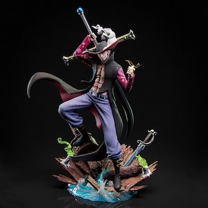 May include: A detailed figurine of a character in a dynamic pose, wearing a black hat, coat, and purple pants. The figure holds a staff and a small object, with a sword at its base. The base features wood, water, and green accents.