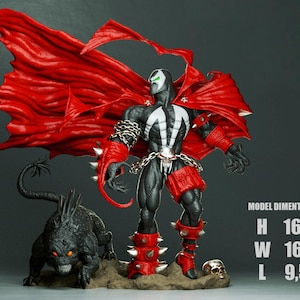 Può includere: Action figure dettagliata di Spawn, un personaggio dei fumetti, con un grande mantello rosso. La figura è nera e bianca con dettagli rossi e si trova accanto a una creatura nera con occhi arancioni brillanti. La figura è alta 41.4 cm.