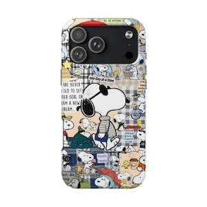 May include: A phone case featuring a collage of Snoopy illustrations in various poses, set against a patchwork background of plaid and other patterns. The case includes text that reads "one day at a time" and "music heals."