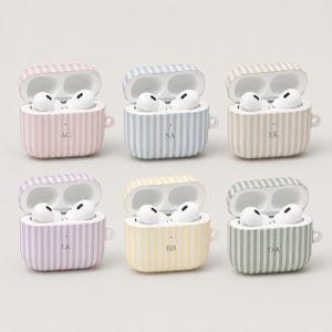 May include: Six open wireless earbud cases with white earbuds inside. Each case features vertical stripes in pastel pink, blue, beige, lavender, yellow, or sage green. Each case is personalized with two-letter initials: AC, SA, EK, LK, BB, or OW.