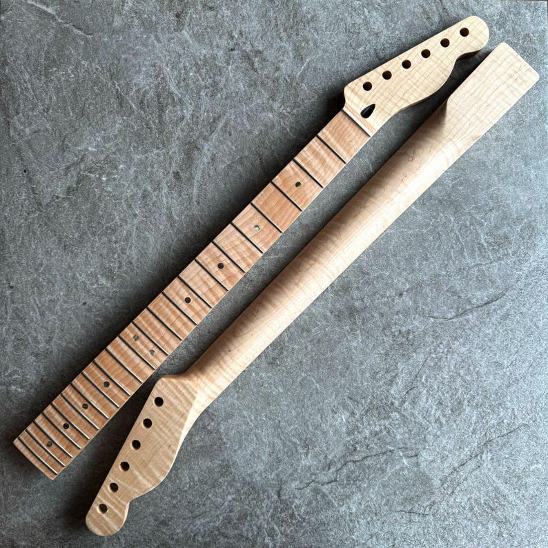May include: Two unfinished maple guitar necks. One neck has frets and dot inlays, the other is a smooth, rounded neck. Both necks have a natural wood grain finish and are ready for assembly.