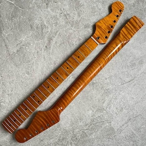 K&ouml;nnte beinhalten: Zwei unfertige Gitarrenh&auml;lse mit geflammtem Ahornmuster. Die H&auml;lse sind warm bernsteinfarben, mit Bundmarkierungen und L&ouml;chern f&uuml;r die Stimmwirbel. Einer ist abgewinkelt, der andere gerade.