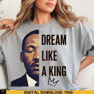 Puede incluir: Sudadera gris con un gráfico de Martin Luther King Jr. y las palabras "DREAM LIKE A KING". El texto está en letras negras, con un pequeño dibujo de corona debajo. Descarga digital.