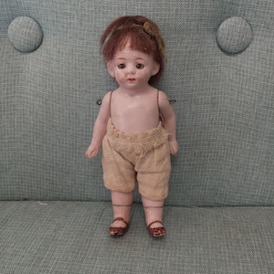 Antique 1900s miniature mignonette bisque doll with jointed limbs, sleepy eyes and brown hair, painted features, socks and shoes