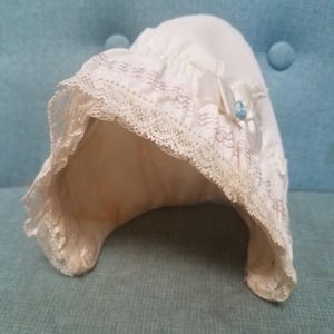 1960s baby bonnet with lace trim and ribbon bow detail