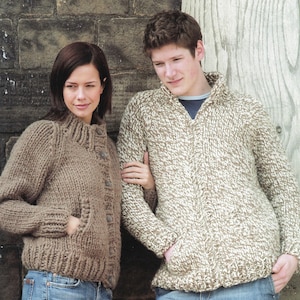 May include: Two knitted sweaters. One is a solid brown with a high collar, button closure, and pockets. The other is a beige and brown speckled zip-up sweater with a high collar and pockets. Both are worn with blue jeans.