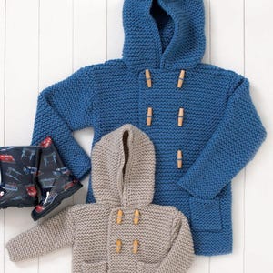 May include: Two knitted hooded coats, one in blue and one in grey, with wooden toggle fastenings and front pockets. The blue coat is larger, suggesting a child and parent set. A pair of black rain boots with a red and blue vehicle pattern are on the left.