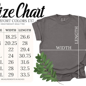 May include: A gray Comfort Colors heavyweight adult tee shirt with a size chart. The chart shows measurements in inches for sizes S to 4XL, with widths from 18.25 to 29 inches and lengths from 26.6 to 33.5 inches. A green leafy sprig is in the lower right corner.