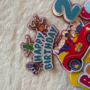 Pu&ograve; includere: Decorazioni di compleanno colorate con la scritta "Happy Birthday" in glitter blu, personaggi dei cartoni animati e un'auto rossa. Ideale per una festa di compleanno.