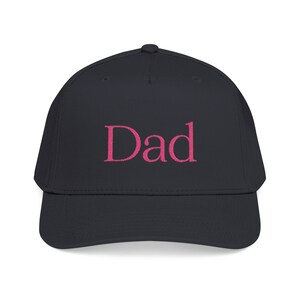 Könnte beinhalten: Eine schwarze Baseballkappe mit dem Wort Dad, das in einer leuchtend pinkfarbenen Serifenschrift auf der Vorderseite eingestickt ist. Die Kappe hat eine strukturierte Krone, einen gebogenen Schirm und einen Knopf oben.
