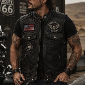 May include: A black leather motorcycle vest featuring a quilted shoulder design, a front zipper closure, and two chest pockets. The vest displays a United States flag patch, a skull patch, and a circular Freedom Rider patch with wings.
