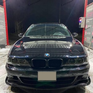 Może przedstawiać: Ciemnoniebieski sedan marki BMW widziany od przodu, z charakterystycznym podwójnym grillem w kształcie nerek, okrągłymi reflektorami i emblematem BMW umieszczonym centralnie na masce. Pojazd ma eleganckie, wypolerowane wykończenie i pustą tablicę.