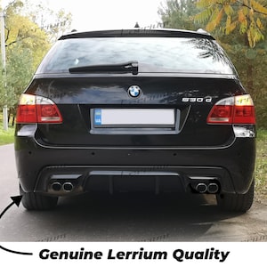 Könnte beinhalten: Ein schwarzer BMW 530d Kombi von hinten gesehen, mit Heckscheibenwischer, rot-weißen Rückleuchten, einem zentralen BMW-Emblem und einem Diffusor-System mit vier Auspuffendrohren. Das Fahrzeug verfügt über einen Bereich für das Kennzeichen.