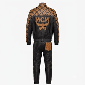 May include: A black leather tracksuit featuring a jacket and pants. The jacket has a tan and black diamond-patterned yoke and sleeves with the MCM logo, and a large MCM logo on the back. The pants include a tan pocket with the MCM logo.