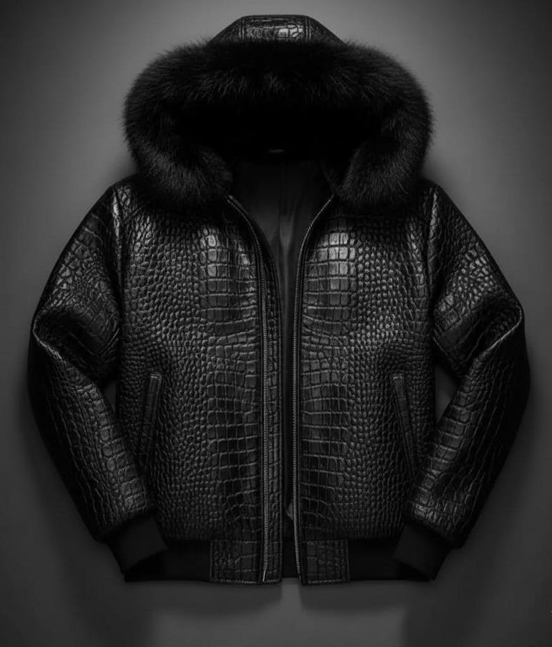 May include: Black leather jacket with a crocodile skin texture, a fur-lined hood, and a zipper closure. The jacket has a bomber-style design with ribbed cuffs and hem. A stylish outerwear piece.