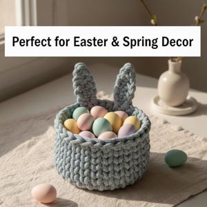 Könnte beinhalten: Ein hellblauer Häkelkorb in Hasenform mit aufrechten Ohren, gefüllt mit pastellfarbenen Ostereiern. Der Text "Perfect for Easter & Spring Decor" wird auf einem weißen Banner angezeigt.
