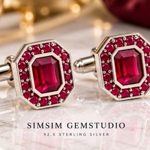 Könnte beinhalten: Ein Paar achteckige Manschettenknöpfe aus 92.5 Sterlingsilber, jeweils mit einem zentralen smaragdgeschliffenen roten Edelstein, umgeben von einem Kranz aus kleineren runden roten Steinen. Der Text SIMSIM GEMSTUDIO 92.5 STERLING SILVER ist zu sehen.