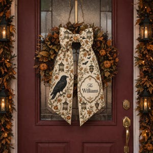 May include: A decorative autumn wreath featuring brown leaves, berries, and small pumpkins, adorned with a large cream-coloured fabric bow. The bow displays a pattern of crows, pumpkins, and cages, with the text The Williams printed on one side.
