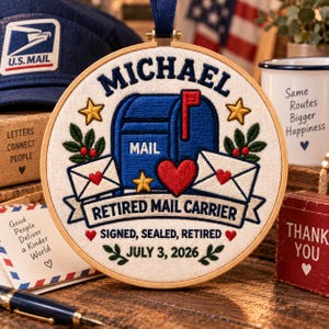 May include: A circular embroidery hoop featuring a blue mailbox, white envelopes, and red hearts on cream fabric. Text reads: MICHAEL, MAIL, RETIRED MAIL CARRIER, SIGNED, SEALED, RETIRED, and JULY 3, 2026. The design includes yellow stars and green leaf accents.