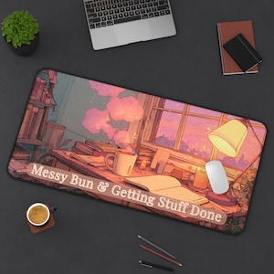 May include: A rectangular desk mat featuring an anime-style illustration of a cozy workspace with a desk, books, a steaming mug, and a lamp. The text "Messy Bun & Getting Stuff Done" is printed in white across the bottom. The scene is bathed in warm pink and orange sunset light.