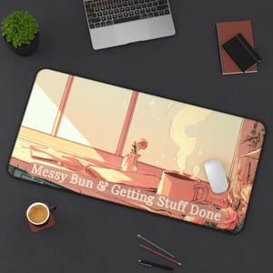 May include: A rectangular desk mat featuring an anime-style illustration of a window view with a steaming mug, a small vase with a flower, and the text "Messy Bun & Getting Stuff Done" printed in white across the lower portion of the mat.