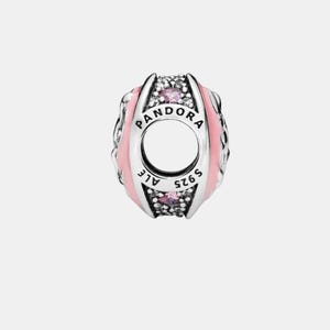 May include: A silver charm with the word "PANDORA" and "ALE S925" engraved. The charm features pink enamel and small pink and clear gemstones. The charm has a hole in the center.