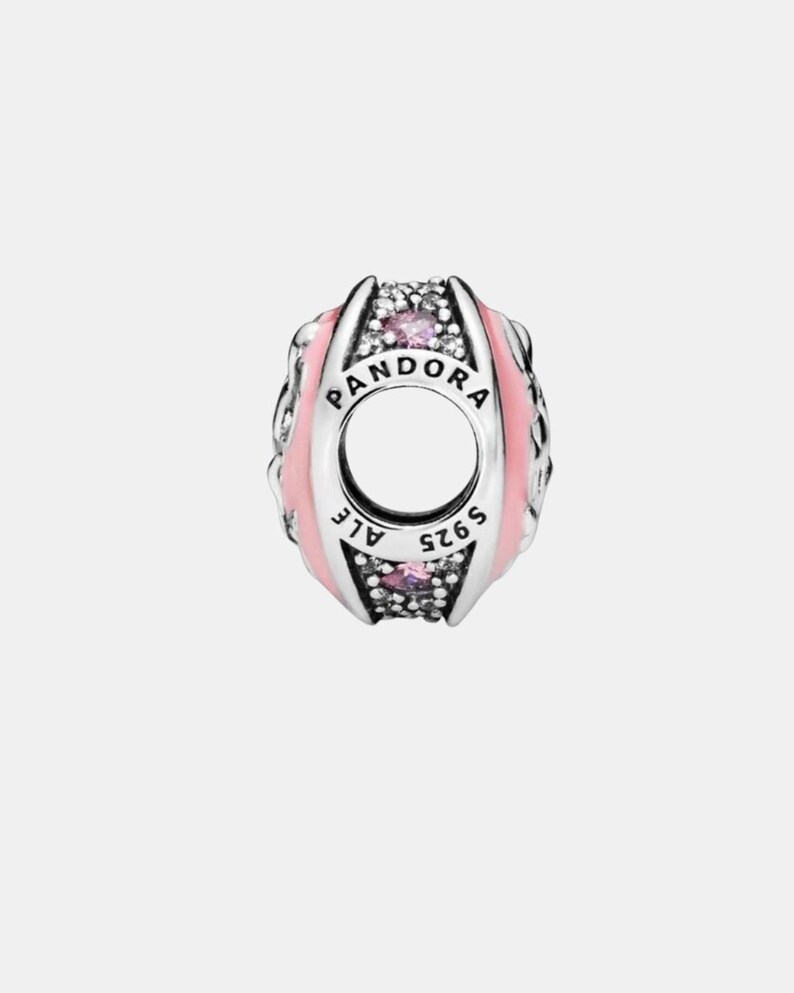 May include: A silver charm with the word "PANDORA" and "ALE S925" engraved. The charm features pink enamel and small pink and clear gemstones. The charm has a hole in the center.