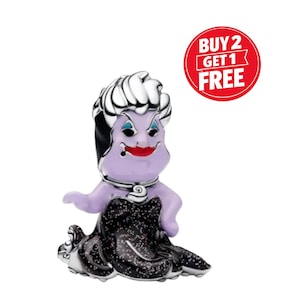 May include: A purple figurine of Ursula from The Little Mermaid, with a black and silver dress, white hair, and red lipstick. The figurine has a silver necklace and is set against a white background. A red circle with the text "BUY 2 GET 1 FREE" is in the background.