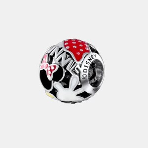 May include: A silver charm with a Minnie Mouse theme. The charm features a red polka-dot bow, the word "MINNIE" in black, a red polka-dot design, and a white glove. The word "DISNEY" is also visible.
