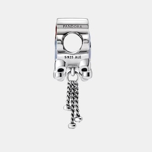 May include: A silver charm with the word "PANDORA" on top. The charm has a large circular opening and a dangling chain with three small, round charms. The text "S925 ALE" is visible.