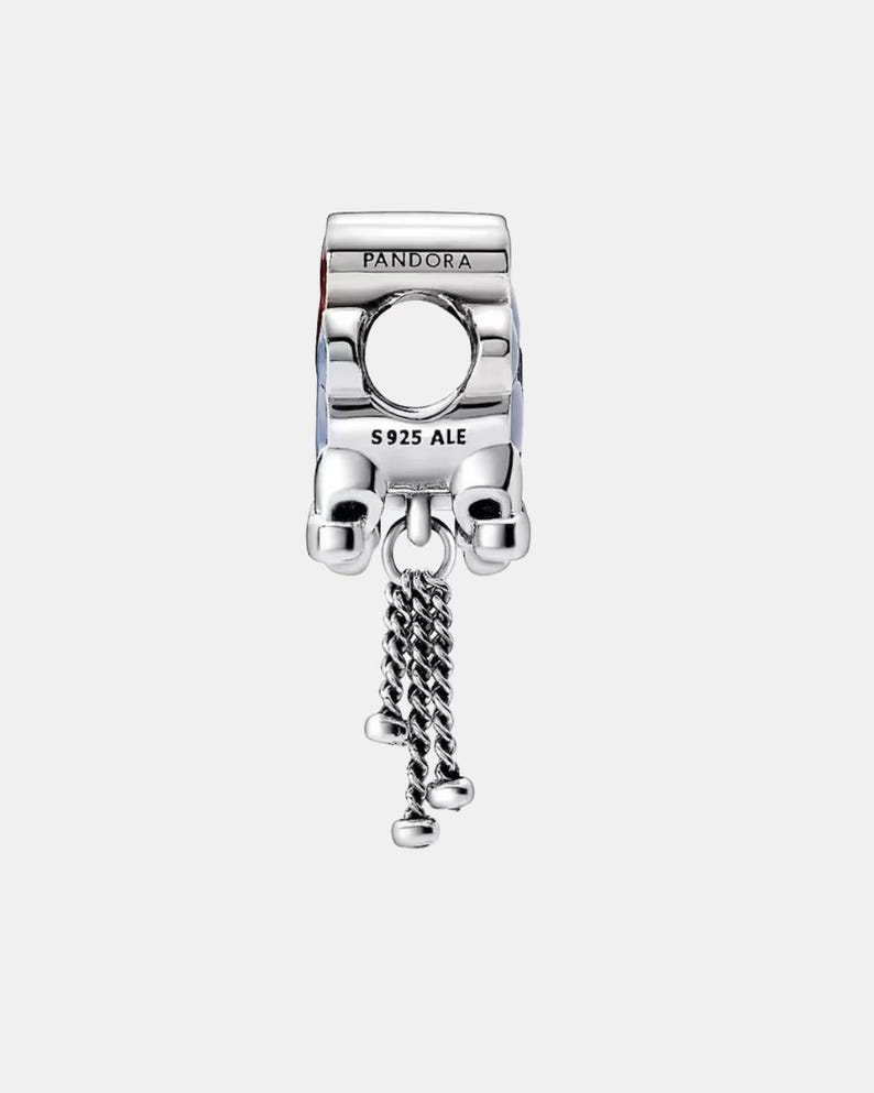 May include: A silver charm with the word "PANDORA" on top. The charm has a large circular opening and a dangling chain with three small, round charms. The text "S925 ALE" is visible.