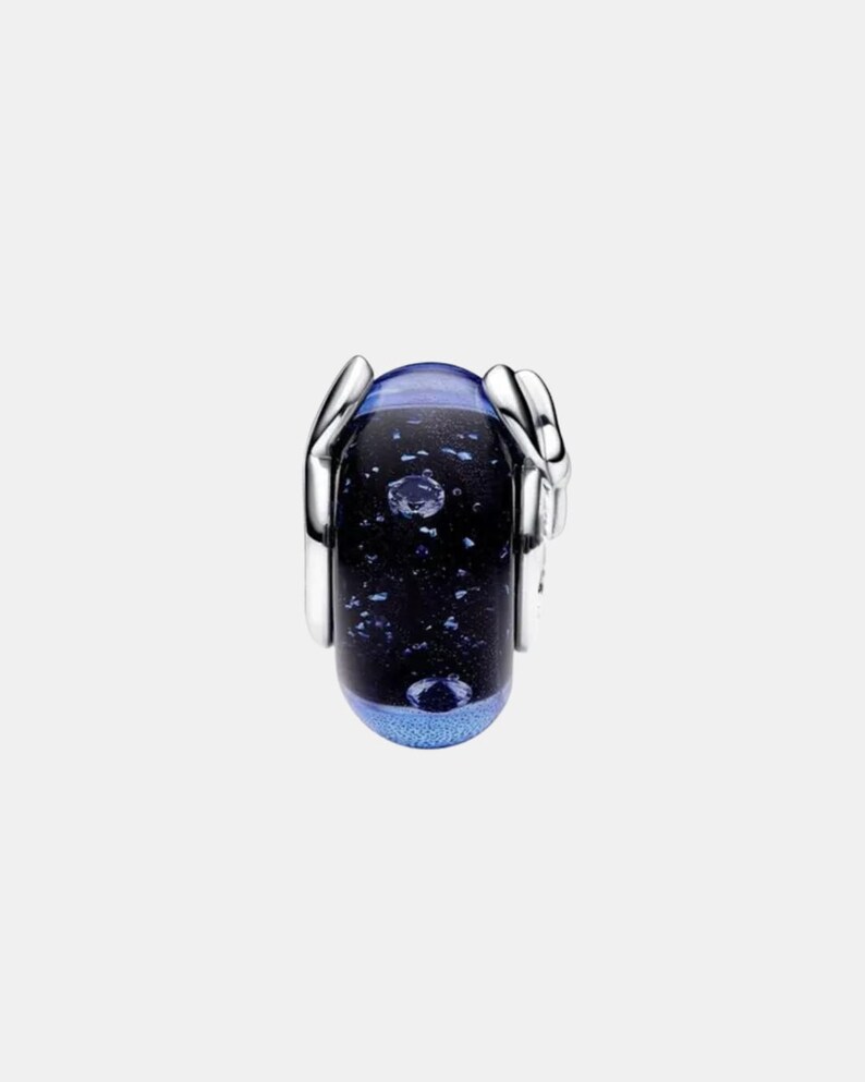May include: A cylindrical charm bead featuring a dark blue and black glass core with embedded shimmering flecks and air bubbles. The glass center is flanked by polished silver-tone metal caps on both sides, creating a sleek, reflective finish.