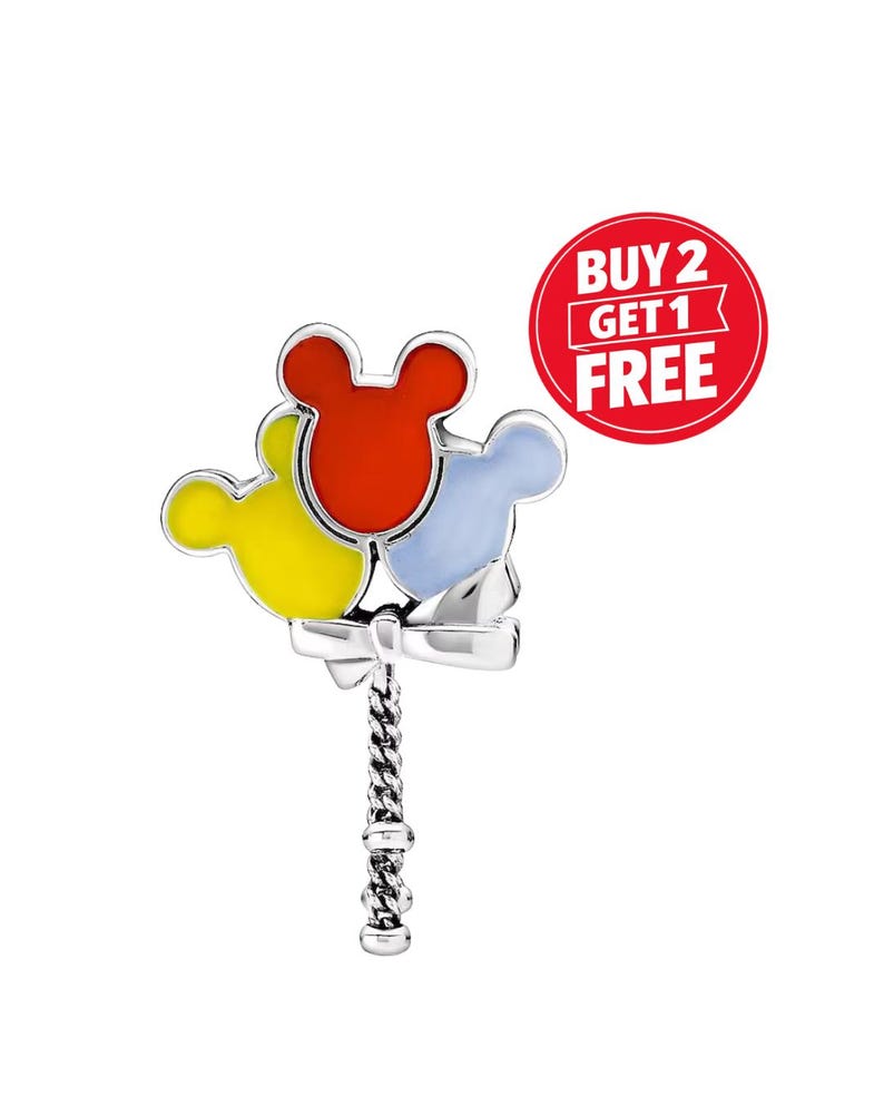 May include: A silver charm featuring three Mickey Mouse head-shaped balloons in red, yellow, and light blue. The balloons are attached to a twisted silver handle. A red circle with the text "BUY 2 GET 1 FREE" is in the background.