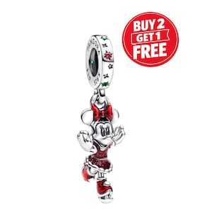 May include: A silver charm featuring a character with a red bow, red dress, and red shoes with glitter accents. The charm hangs from a silver ring engraved with the word PANDORA and S925, decorated with small red and green star-shaped stones.